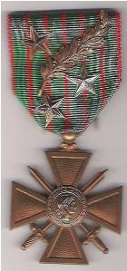 La Croix de guerre 1914-1918, décoration militaire attribuée pour récompenser l'octroi d'une citation par le commandement militaire pour conduite exceptionnelle au cours de la Première Guerre mondiale – Ici, une croix avec 4 citations, une palme de bronze, une étoile de vermeil, une étoile d'argent et une étoile de bronze [Source : Wikipedia].